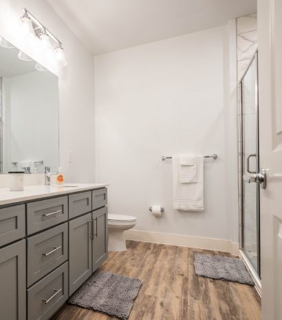 Modern bathroom featuring double vanity, glass shower, and stylish fixtures.